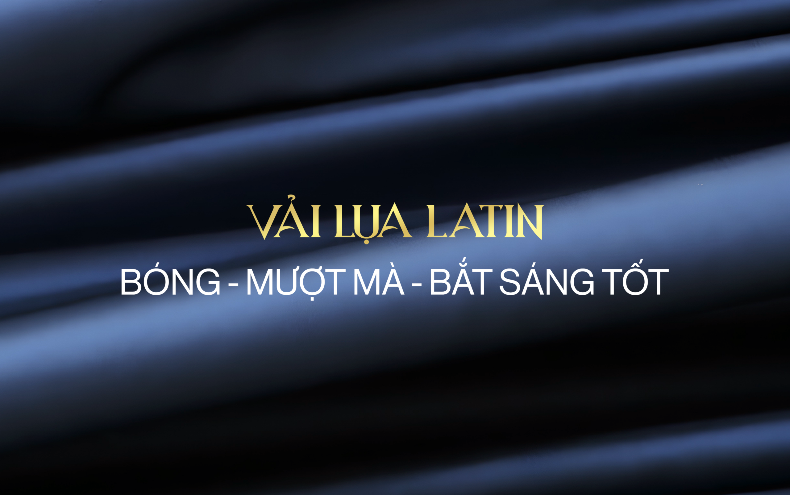 Hình ảnh các nếp gấp của vải lụa latin màu xanh dương đậm thể hiện rõ độ bóng bẩy, kèm theo dòng chữ mô tả đặc tính nổi bật của vải: "Vải lụa latin: Bóng - Mượt mà - Bắt sáng tốt
